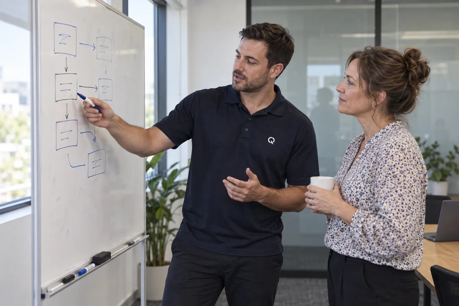 SEQ IT consultant and an office manager planning security improvements at a whiteboard